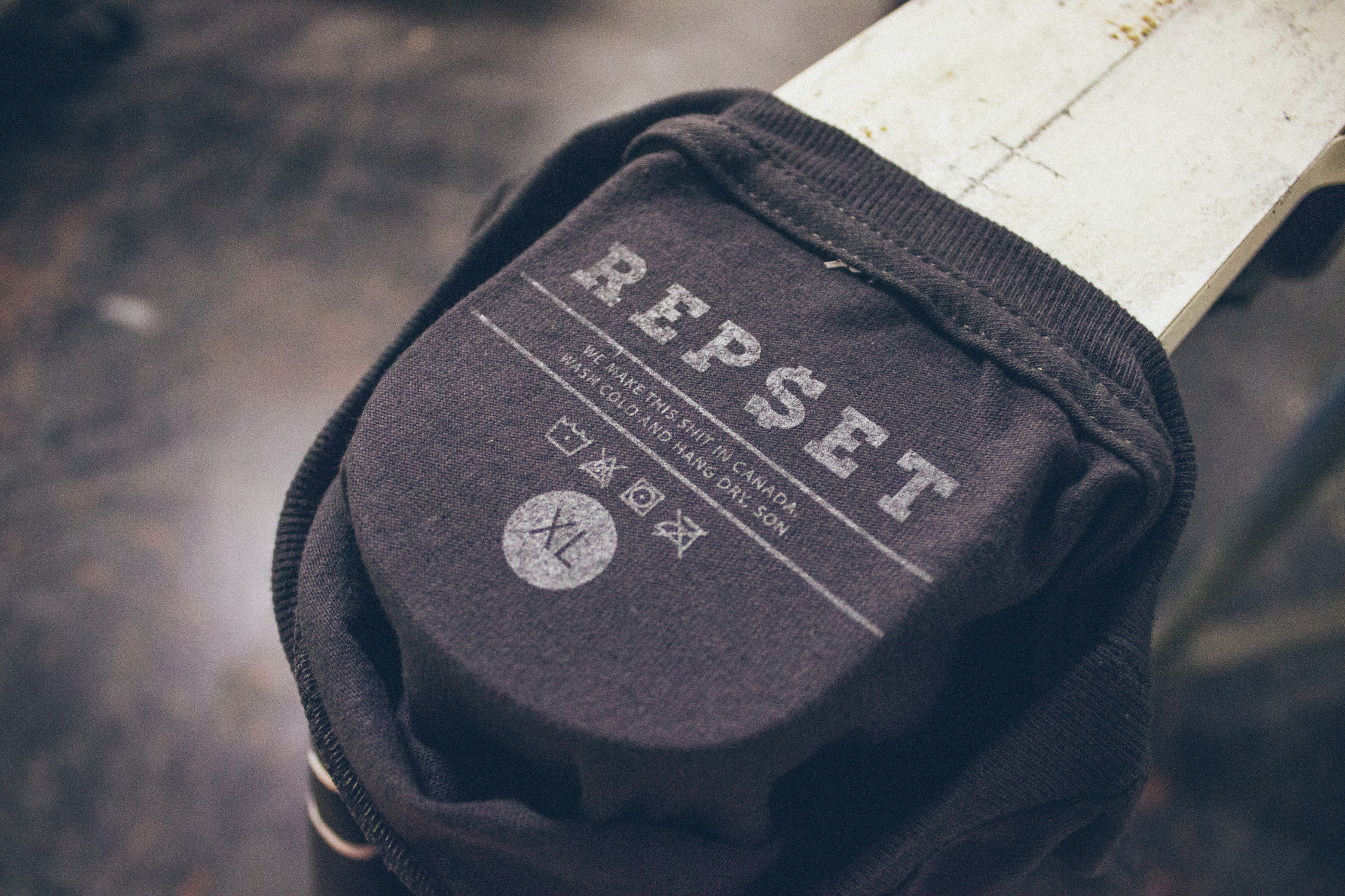 Charcoal tee with a Repset inside-neck tag print and care details in place of a sewn label